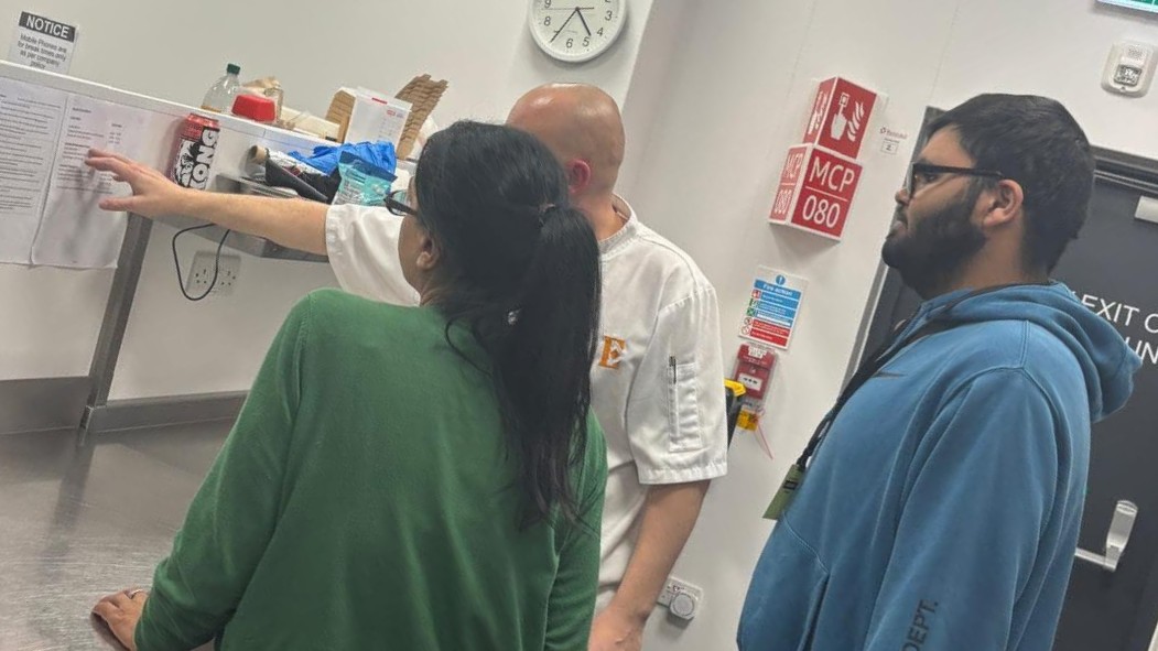 A parent and young person visiting a workplace kitchen placement with a chef